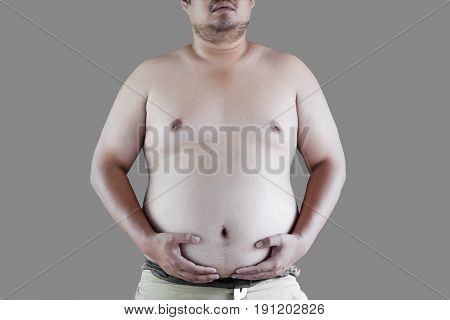 Fat Asian man belly and chest, isolated on gray background