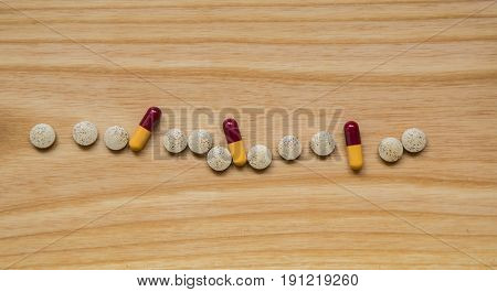 Lot Of Colorful Pills On A Wooden Table