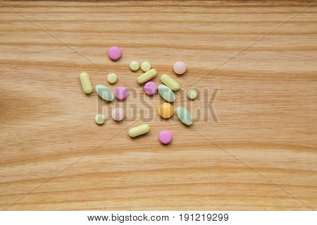 Lot Of Colorful Pills On A Wooden Table