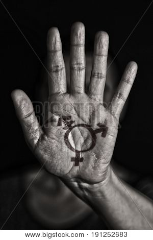 closeup of a transgender symbol painted in the palm of the hand of a young caucasian person in black and white