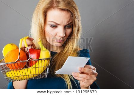 Worried Woman Holding Shopping Basket With Fruits