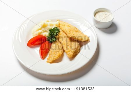Fish In Breadcrumbs With Garlic Sauce On The White Background