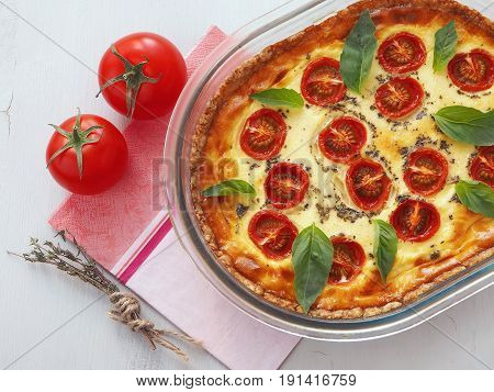 Rustic pie with vegetables and cheese. French quiche. Vegetarian tart with spinach, ricotta and cherry tomatoes. Top view.