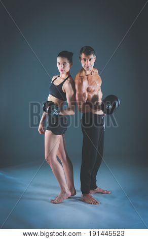 Athletic man and woman with a dumbells. Personal fitness instruc