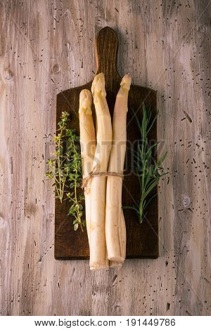 Few Pieces Of Asparagus On Chopping Board With Herbs