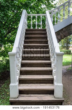 White wooden staircase of gazebo-pavilion in old park