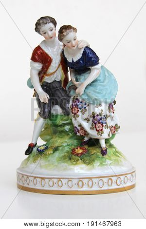 old ceramic figurine boy and girl on green grass
