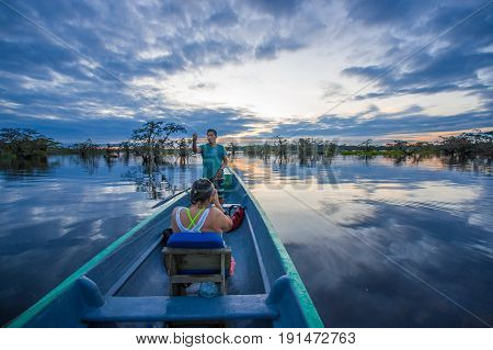 CUYABENO, ECUADOR - NOVEMBER 16, 2016: Unidentified people enjoying the sunset from the river in Cuyabeno National Park, Ecuador.