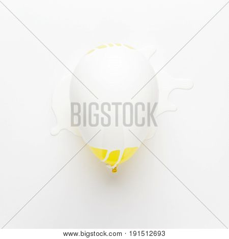 yellow balloon painted white. white paint poured over yellow balloon. repanted yellow balloon. not isolated yellow balloon on white background