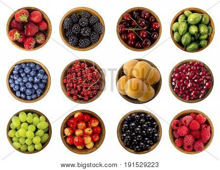 Collage of fruits and berries. Blueberries blackberries cherries grapes strawberries currants raspberries wild strawberries bilberries gooseberries and pomegranate. Collection of fruits and berries isolated on a white background. Top view.