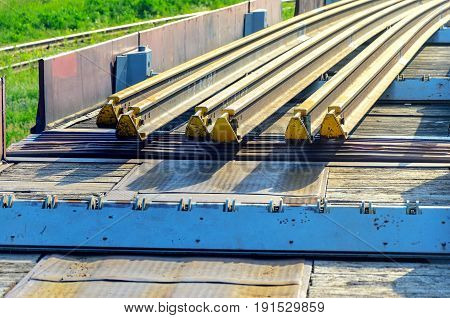 Railhead elements. Transportation of long new rails on a freight car. Endless path. The rail lash. Special load.