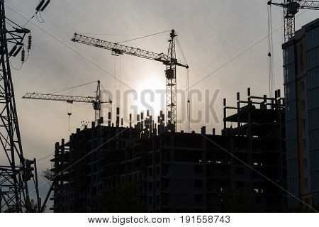 construction site with working crane at dusk