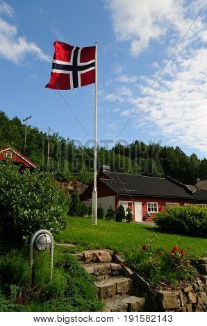 The Norwegian flag is waving against a blue sky, as I approached my first overnight stop in Norway. As small but nice hostel in Froland.