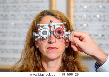 Optican Checking Eyes Of Woman For New Glasses