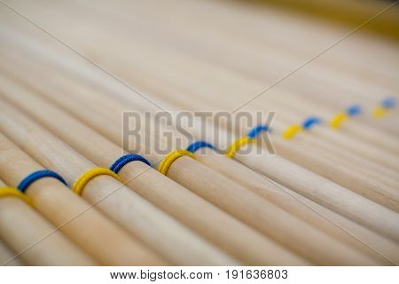 The pattern is a lot of wooden sticks woven with blue and yellow ntkami lie closely related.