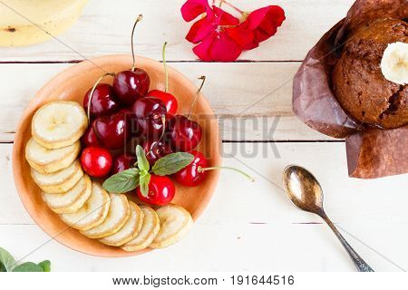 Cherry and sliced banana on a plate. Copy space.