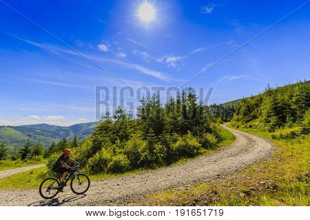 Mountain biking women riding on bike in summer mountains forest landscape. Woman cycling MTB outdoor sport activity.