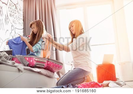 Sisters cleaning bedroom