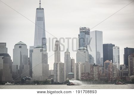 Eric McAllister harbor tugboat sprays water as it passes the Freedom Tower and World Trade Center Financial District for Parade of Ships at start of Fleet Week New York, JERSEY CITY NJ MAY 24 2017.