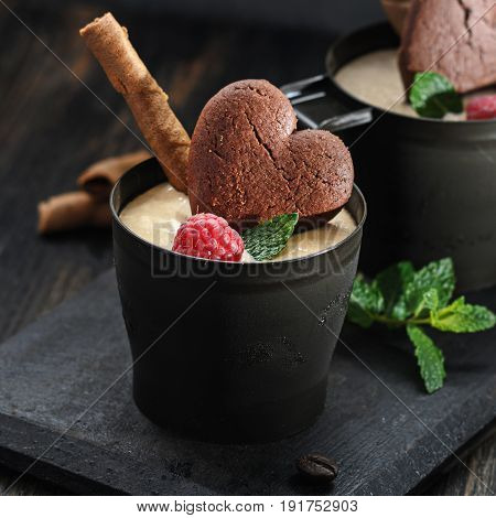 Coffee  ice cream with raspberries on black wooden background free text space.
