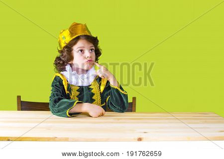 Little Curly King Sternly Looking Up. Green Suit. Yellow Background.