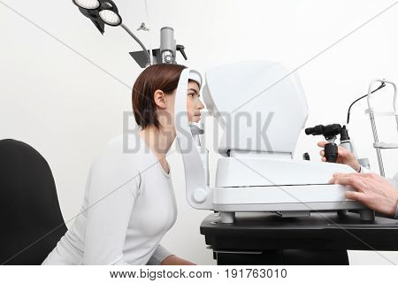 woman doing eyesight measurement with optician slit lamp
