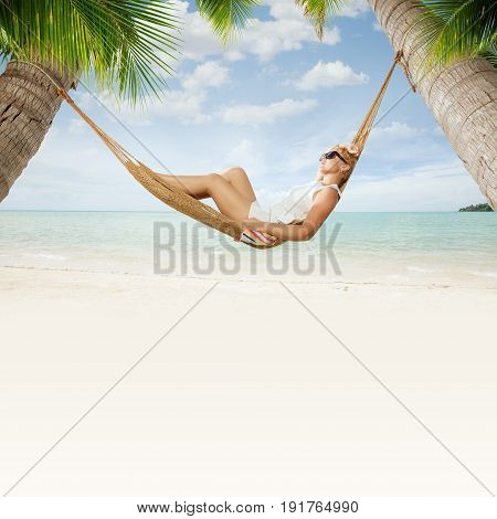view of nice young lady swinging  in hummock on tropical beach