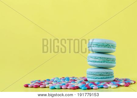 Macaroons selected focus toned  on plain bright yellow background
