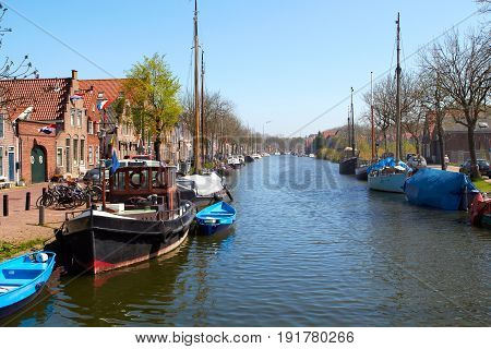 Traditional Dutch Botter Fishing Boats in the small Harbor of the Historic Fishing Village of Spakenburg-Bunschoten in the Netherlands. The village was at one time a harbor on the inland sea. Sprinf sunny day