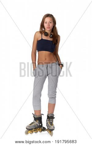 The beautiful girl with earphones in rollerskates on a white background.