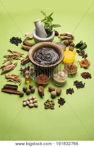 Flat lay of a bowl of Chyawanprash or chyavanprash and all its ingredients on a green background.