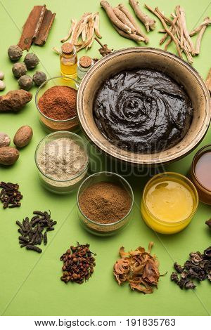 Flat lay of a bowl of Chyawanprash or chyavanprash and all its ingredients on a green background.
