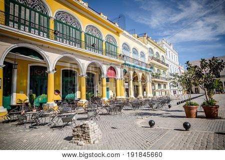 Colorful buildings of yellow blue and green on the square in Havana.