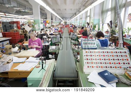 MOSCOW - FEB 21, 2017: Workers near transporter in workshop of Ralf Ringer factory. In 1995 Ralf Ringer started manufacturing its own shoes
