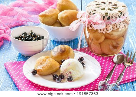 Small rich sponge cake baba typically soaked in rum-flavored syrup. Canned sponge cake rum baba in jar. Is related to brioche and savarin. Served with ice cream rum syrup and blackcurrant