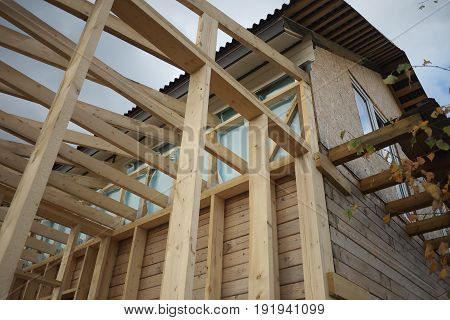 New home roof construction with wooden house frame.
