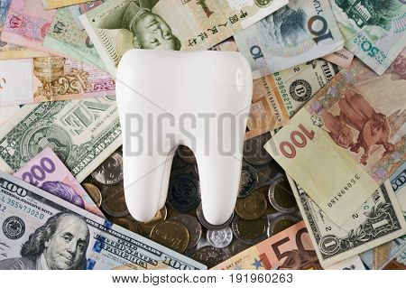 White healthy tooth on money from different countries.Dental implant on money. Financial Concept. Dentist Money concept. Healthcare reform concept. Medical insurance medicare reimbursement.