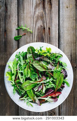 Mix Of Fresh Leaves With Arugula, Lettuce, Beets. Ingredients For Salad On A Wooden Background.