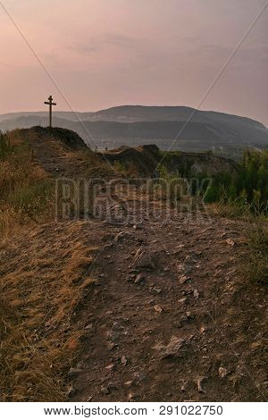 Thorny Path To God. Stony Path Leading To The Cross. Summer Sunrise. On The Horizon Are Small Mounta