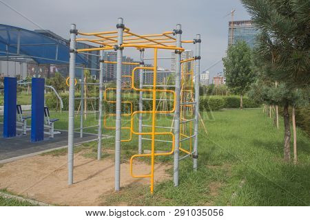 Exercise Equipment In A Public Park In A Sunny Day. Sidewalk Outdoor Exercise Equipmen