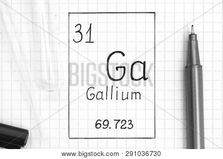 The Periodic table of elements. Handwriting chemical element Gallium Ga with black pen, test tube and pipette. Close-up.