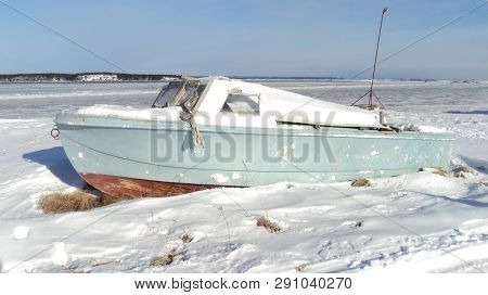 fishing boat on the snow at the edge of a river