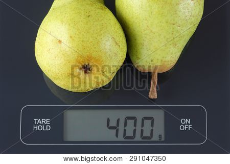 Two Green Pears On Digital Scale Displaying 400 Gram.