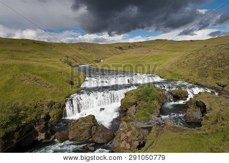 Countryside With Trail Near Famous Skogafoss Waterfall, Iceland On Sunny Summer Day And Blue Sky