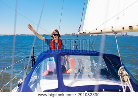 Kids Sail On Yacht In Sea. Child Sailing On Boat. Little Boy And Girl In Safe Life Jackets Travel On
