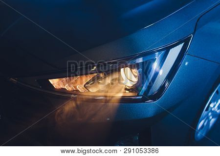 In The Automobile Salon Garage, Center The Headlights Of The Car Are Very Close, Turning On Turning 