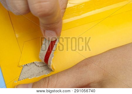 Woman Hands Opening Mail Package With Easy Open Strip.