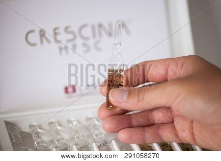 Paphos, Cyprus - November 13, 2015 Woman Hand With Ampoule Of Crescina Re-growth In Front Of Crescin