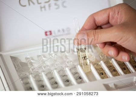 Paphos, Cyprus - November 13, 2015 Woman Hand With Ampoule Of Crescina Re-growth In Front Of Crescin