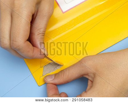 Woman Hands Opening Mail Package With Easy Open Strip.